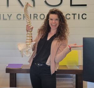 Friendly portrait of the website owner holding a spine model.