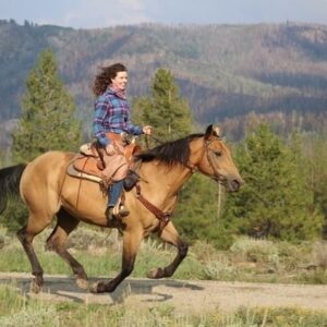 Website owner horseback riding on a trail outdoors.