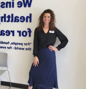 Smiling website owner standing indoors.