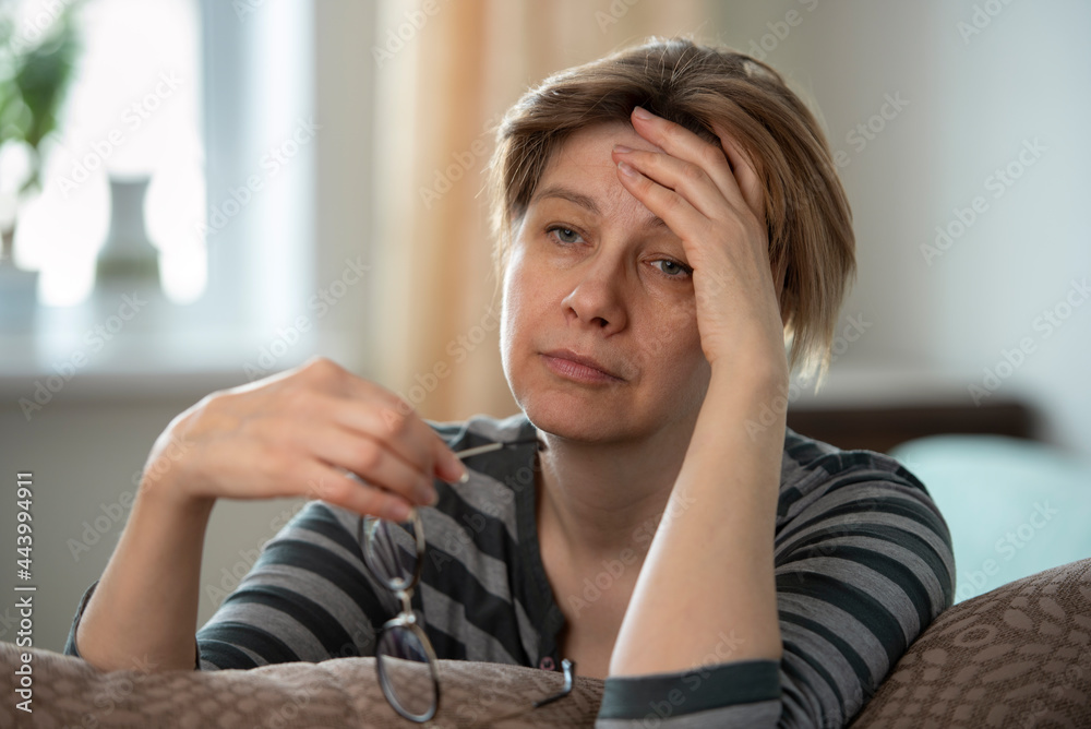 Woman resting her head on her hand, showing signs of fatigue.